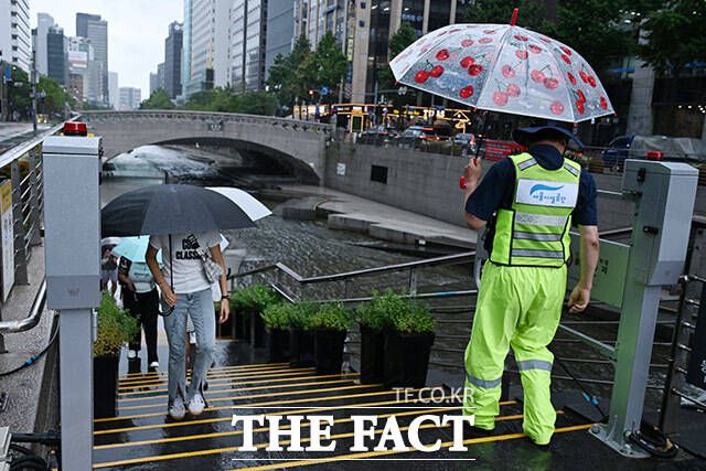 출입 통제 알리며 청계천에 있는 시민들 이동시키는 관계자.