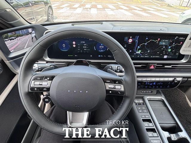 운전석에서 바라본 조향 휠과 디지털 클러스터·인포테인먼트 화면. 좌측은 속도계 및 주행 정보, 스티어링 휠 좌우에는 주행 보조, 미디어, 크루즈 컨트롤 버튼이 배치돼 있고, 사이드미러 카메라 화면도 계기판 옆에 띄워져 있다. /황지향 기자