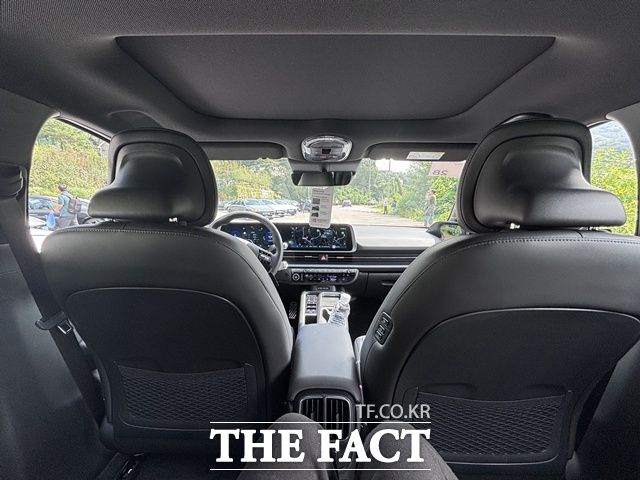 2열 좌석에서 바라본 실내 전경. 대시보드와 듀얼 스크린 구성이 보이며, 앞좌석 뒷면에는 수납망과 뒷좌석 전용 송풍구가 마련돼 있다. 뒷좌석에서도 전방 시야가 비교적 넓게 확보되는 구성이 특징이다. /황지향 기자