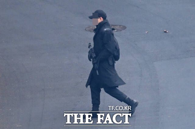 내란 우두머리 혐의를 받는 윤석열 전 대통령의 재판에서 지난 1월 윤 전 대통령의 1차 체포영장 집행 저지 이후 대통령 경호처 내부에서 권총과 공포탄을 준비하라고 지시했다는 증언이 나왔다. 사진은 지난 1월 윤 전 대통령 1차 체포영장 집행 저지 이후 대통령 관저에서 경호처 관계자가 소총을 지닌 채 경내를 이동하고 있는 모습. /이새롬 기자