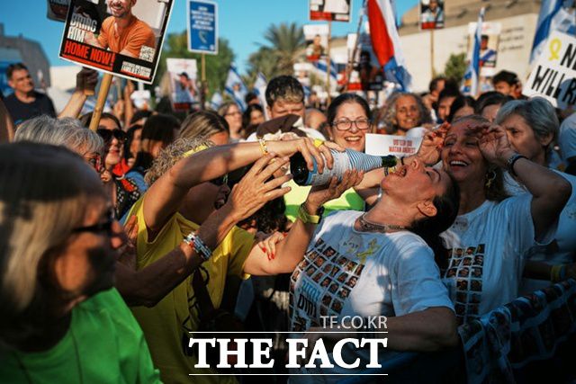 13일(현지 시간) 이스라엘 텔아비브의 ‘인질 광장'에서 시민들이 가자지구에서 석방된 이스라엘 인질들의 모습을 생중계로 지켜보며 기뻐하고 있다. /텔아비브=AP/뉴시스