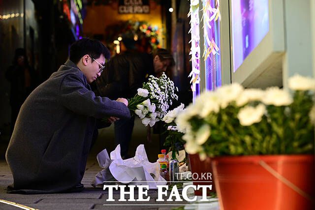 한 시민이 헌화를 위해 꽃다발을 정리하고 있다.