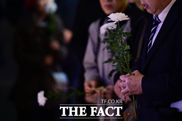 이태원 참사 3주기인 지난 10월29일 오후 서울 용산구 이태원동 '10·29 기억과 안전의 길'을 찾은 추모객이 국화를 들고 기도하는 모습. /남윤호 기자