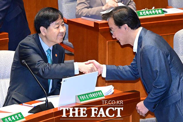 전재수 해수부 장관(오른쪽)과 악수하는 구윤철 부총리.