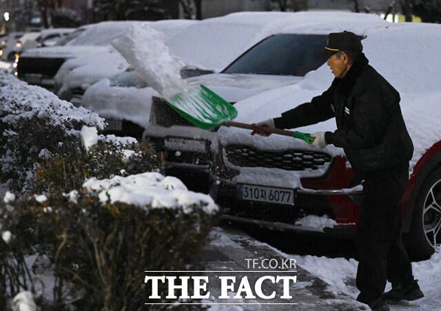 아파트 단지에서 경비원이 전날 내린 눈을 치우고 있다.