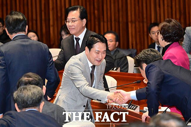 장동혁 국민의힘 대표(가운데)와 송언석 원내대표가 의원총회 및 이재명 정권 독재악법 국민고발회에 참석해 의원들과 악수하고 있다.