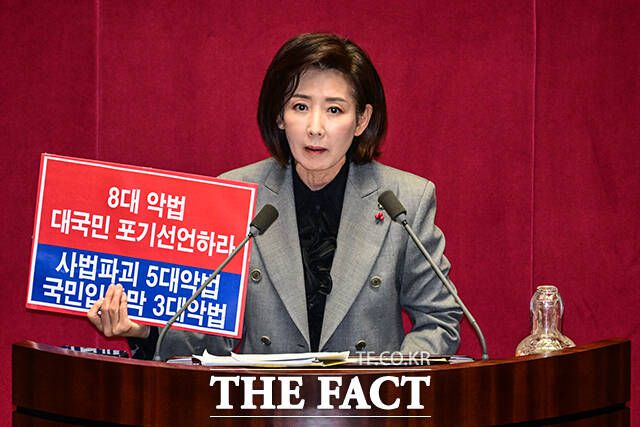나경원 국민의힘 의원이 9일 오후 서울 여의도 국회에서 열린 본회의에서 '가맹사업거래의 공정화에 관한 법률 일부개정법률안'에 대한 무제한 토론에 나서며 '8대 악법 대국민 포기선언하라' 라고 적힌 손팻말을 들고 있다. /국회=남윤호 기자
