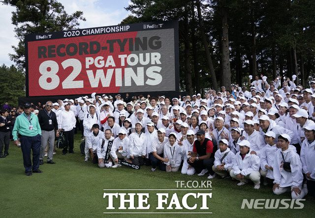 2019년 일본 지바현에서 열린 조조오픈 우승으로 통산 82승을 기록한 타이거 우즈가 자원봉사자들과 함께 기념촬영을 하고 있다./AP.뉴시스