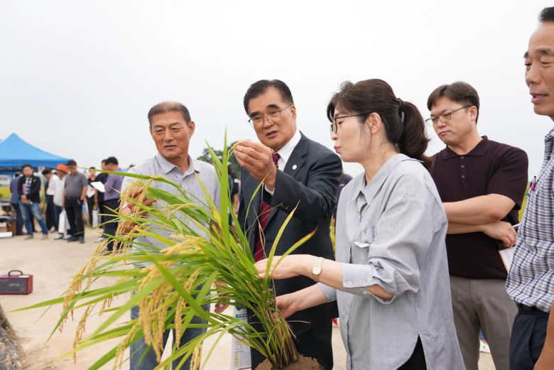 김기웅 군수가 벼 직파재배 평가회 참석하여 생산성에 대해 질문하고 있다(서천군)