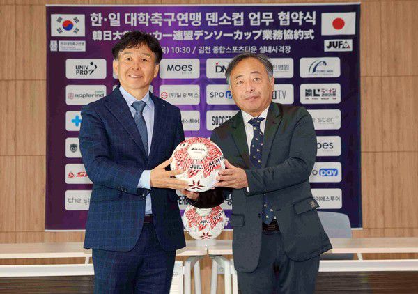 중앙대 감독이자 한국축구연맹 상비군 사령탑인 오해종 감독이 결승전에 앞서 열린 ‘한-일 대학축구연맹 덴소컵 업무 협약식’에서 일본대학축구연맹 나가지 유지 회장으로부터 덴소컵 공인구 전달받은 후 기념 촬영에 임하고 있다(사진=김병용 기자)
