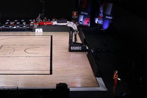 밀워키 벅스가 흑인 남성에 대한 경찰의 과잉 총격에 대한 항의로 NBA플레이오프를 보이코트한 가운데 27일(한국시간) NBATV 리포터가 텅빈 코트에서 경기 보이코트 소식을 전하고 있다.올랜도 | AFP연합뉴스