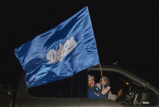 다저스 팬들이 지난 10월 28일 32년 만에 월드시리즈 정상을 탈환한 LA 다저스의 깃발을 흔들며 기쁨을 누리고 있다. UPI연합뉴스
