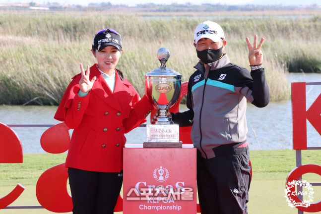 박현경(왼쪽)이 2일 열린 크리스F&C 재43회 KLPGA 챔피언십에서 우승한 뒤 프로 출신의 아버지와 함께 우승트로피를 놓고 활짝 웃고 있다. /KLPGA제공