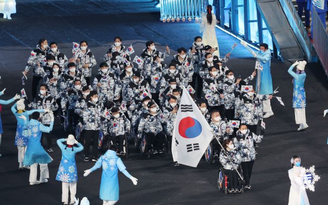 4일 오후 중국 베이징 국립경기장에서 열린 2022 베이징 패럴림픽 개회식에서 대한민국 선수단의 기수를 맡은 휠체어컬링 대표팀 ‘장윤정 고백’의 리드 백혜진이 태극기를 앞세우고 입장하고 있다.  베이징|연합뉴스