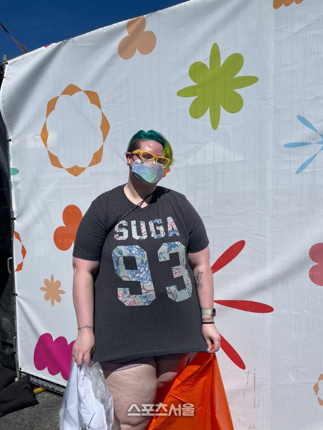 바하마에서 온 캔더스가 방탄소년단 멤버 슈가의 이름이 그려진 티셔츠를 보여주고 있다.