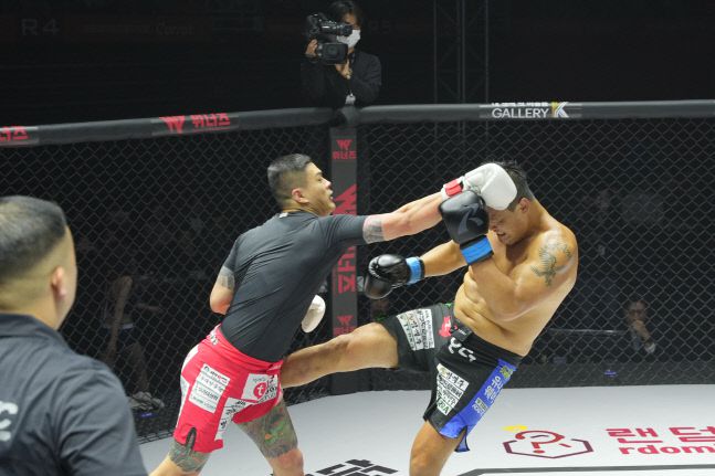 명현만과 황인수가 25일 경기도 고양시 일산서구 고양종합체육관에서 열린 ‘굽네 로드FC 063’ 메인 이벤트 무제한급 킥복싱 매치에서 펀치와 킥을 주고받고 있다. 사진 | 로드FC