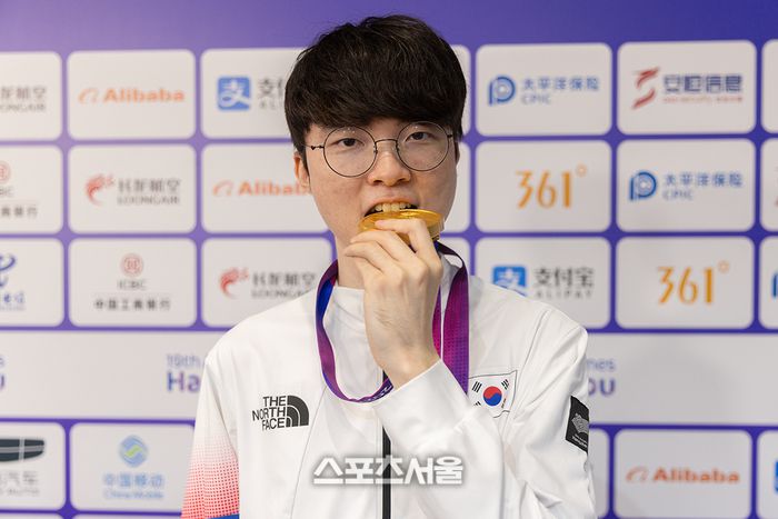 한국 LoL 대표팀의 맏형 ‘페이커’ 이상혁이 항저우 아시안게임 금메달을 깨물고 있다. 사진 | 공동취재단