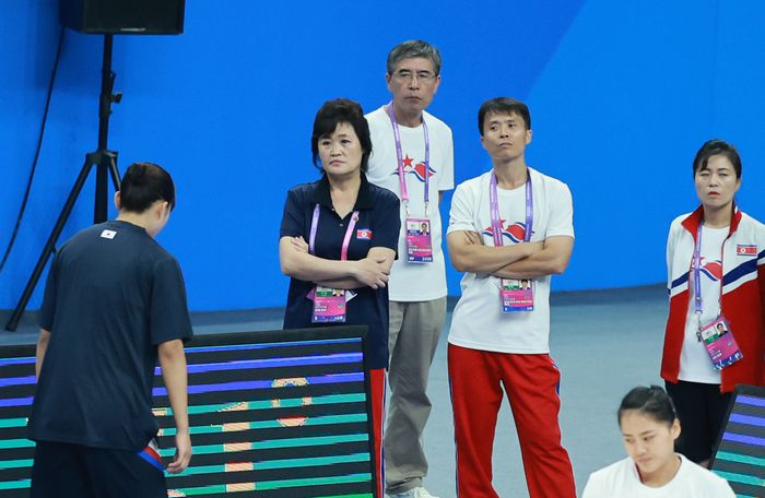 29일 중국 저장성 항저우의 올림픽 스포츠센터에서 열린 2022 항저우 아시안게임 여자 농구 대한민국과 북한의 경기에 앞서 연습을 마친 대한민국 선수가 북한 정성심 감독과 북한 코칭스태프 앞을 지나며 목례를 하고 있다. 사진 | 항저우=연합뉴스