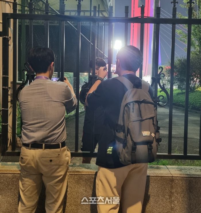 철장을 사이에 두고 황재원과 인터뷰하는 취재진.