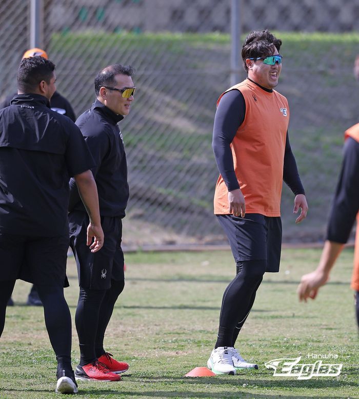 한화 류현진(오른쪽)이 2월28일 일본 오키나와 고친다 구장에서 진행된 훈련에 앞서 장세홍 코치(왼쪽 두 번째)와 함께 몸을 풀며 웃음을 보이고 있다. 사진 | 한화 이글스