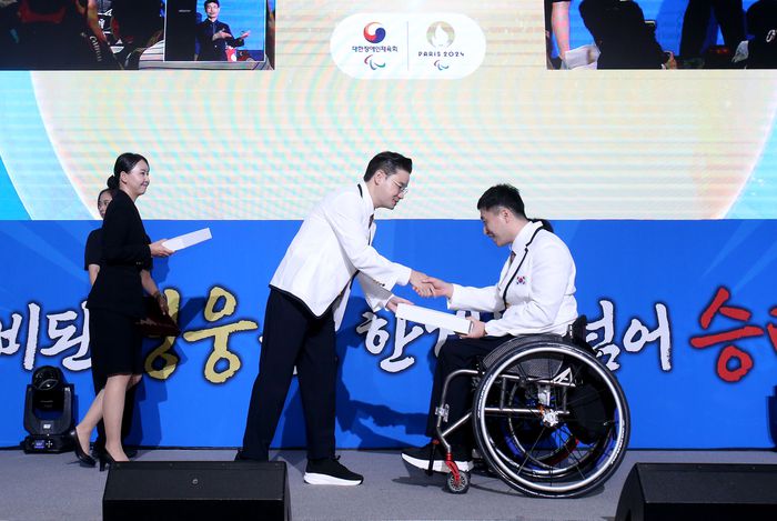 배동현 선수단장이 12일 서울올림픽파크텔에서 열린 2024 파리 패럴림픽 대한민국 선수단 결단식에서 선수들에게 선물을 전달하고 있다. 사진 | 대한장애인체육회