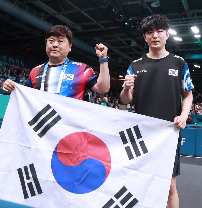 탁구 대표팀 김기태(오른쪽)와 김정중 코치가가 6일(한국시간) 프랑스 파리 사우스 파리 아레나4에서 열린 2024 파리 패럴림픽 탁구 남자단식(MS11) 금메달을 따낸 후 태극기를 들고 포즈를 취했다. 사진 | 대한장애인체육회