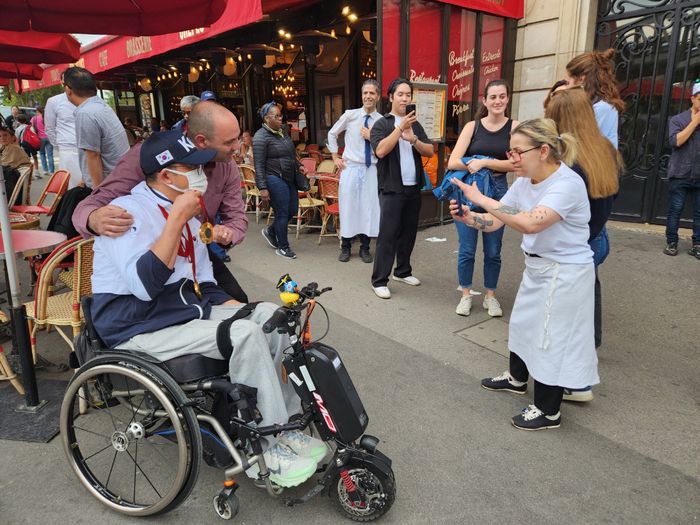 2024 파리 패럴림픽 사격 2관왕 박진호가 8일(한국시간) 프랑스 파리 에펠탑 인근에서 인터뷰를 마친 후 파리 현지 시민들과 사진 촬영에 임했다. 사진 | 대한장애인체육회
