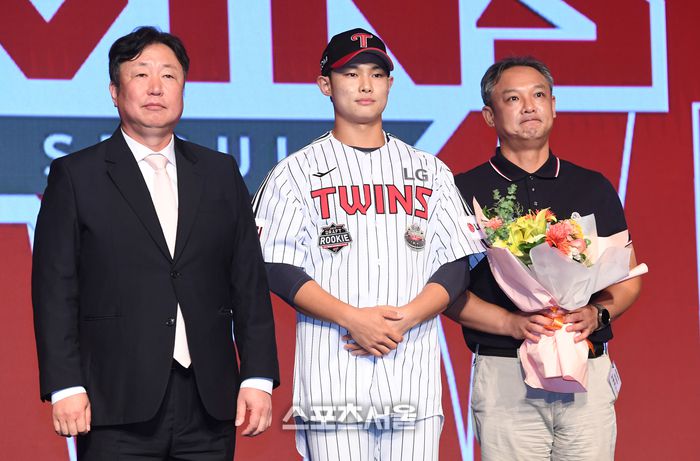 서울고 투수 김영우(가운데)가 11일 서울 송파구 롯데호텔 월드 크리스탈 볼룸에서 열린 ‘2025 KBO 신인 드래프트’에서 전체 10순위로 LG에 지명된 뒤 차명석 단장(왼쪽), 아버지와 함께 취재진을 향해 포즈를 취하고 있다. 2024. 9. 11. 박진업 기자 upandup@sportsseoul.com