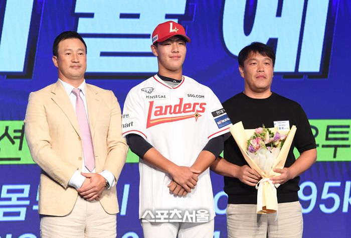 강릉고 포수 이율예(가운데)가 11일 서울 송파구 롯데호텔 월드 크리스탈 볼룸에서 열린 2025 KBO 신인 드래프트에서 전체 8순위로 SSG에 지명된 뒤 김재현 단장(왼쪽), 아버지와 함께 취재진을 향해 포즈를 취하고 있다. 박진업 기자 upandup@sportsseoul.com