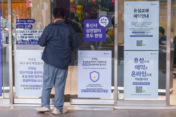 SKT 유심 해킹사태로 인힌 혼란이 커지며 유통ㆍ물류업계도 보안을 강화하고 있는 가운데 서울 시내 한 SKT 매장에 유심 교체 관련 안내문이 붙어있다. 사진 | 연합뉴스