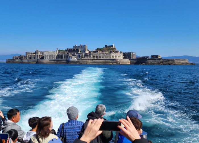 유람선에서 군함도를 바라보는 관광객들