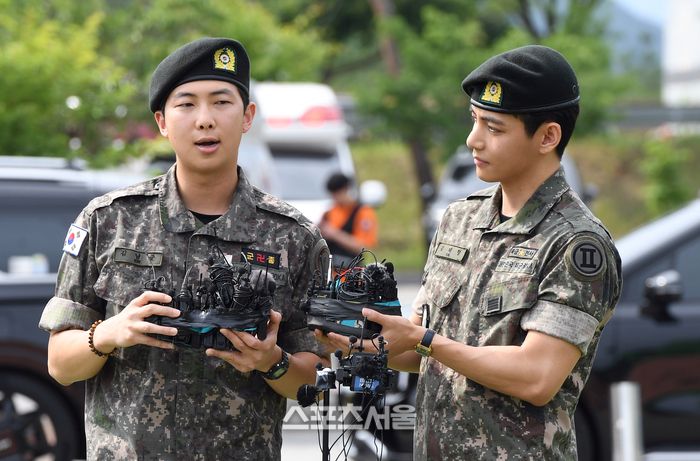 방탄소년단(BTS)의 RM(왼쪽, 김남준)과 뷔(김태형)가 10일 강원도 춘천시 신북읍 체육공원에서 진행된 전역 행사에서 소감을 밝히고 있다.RM은 육군 제15보병사단 군악대에서, 뷔는 2군단 군사경찰 특수임무대에서 1년 6개월 동안 군복무를 했다. 2025. 6. 10. 춘천 | 박진업 기자 upandup@sportsseoul.com