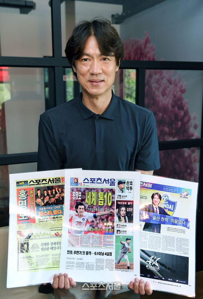 홍명보 감독이 스포츠서울 40년사에 자신의 발자취가 담긴 지면을 들고 포즈를 하고 있다.