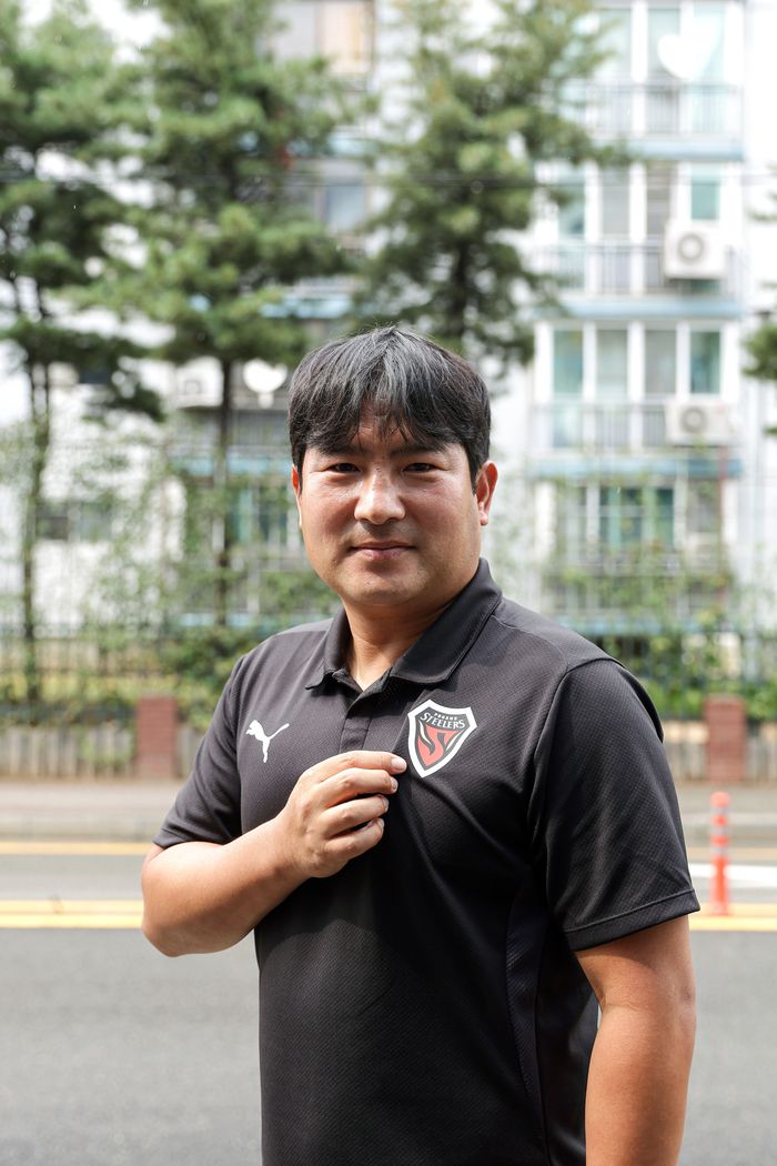 포항 U-18(포항제철고) 황지수 감독이 14일 인터뷰를 마친 뒤 엠블럼을 가리키고 있다. 사진｜한국프로축구연맹