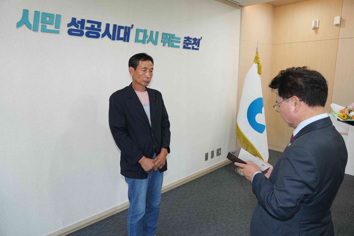육동한 춘천시장이 신속한 현장 대응으로 시민 안전에 기여한 신동면 증4리 김영호 이장에게 감사패를 수여하고 있다.  사진|춘천시청