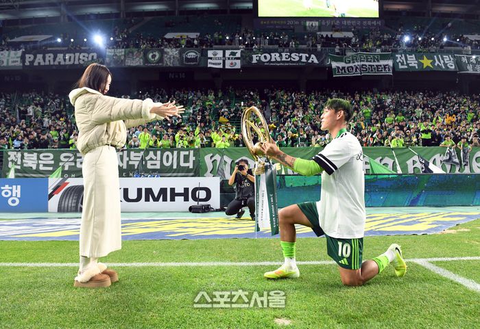 전북 현대의 송민규(오른쪽)가 8일 전주월드컵경기장에서 열린 하나은행 K리그1 대전 하나 시티즌과 경기 후 진행된 우승 기념 행사에서 팬들 앞에서  결혼을 앞둔 곽민선 아나운서에게 무릎을 꿇고 트로피를 건네고 있다. 2025. 11. 8. 전주 | 박진업 기자 upandup@sportsseoul.com