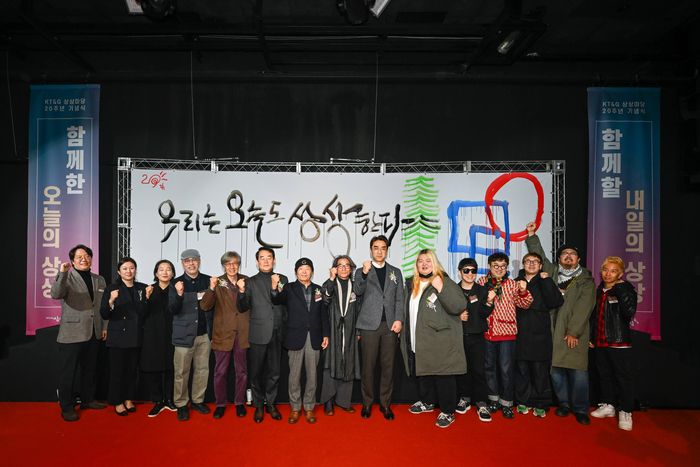 KT&G가 지난 3일 상상마당 20주년을 맞아 기념행사를 열었다. 사진은 강병인 캘리그라퍼의 퍼포먼스 작품을 배경으로 강병인 작가(가운데), 배수민 KT&G 지속경영본부장(오른쪽 일곱번째)를 비롯한 주요 예술가들이 기념촬영을 하고 있는 모습. 사진 | KT&G