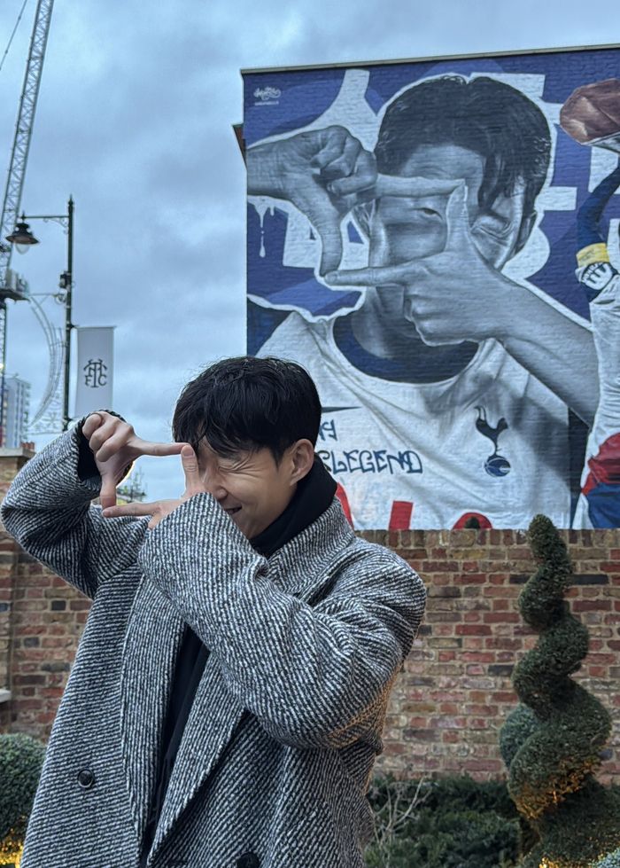 손흥민이 자기 벽화 공개 행사에 참석해 찰칵 세리머니하며 웃고 있다. 사진 | 토트넘 구단 SNS