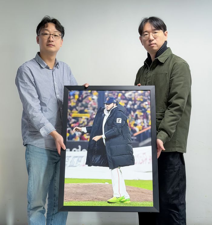 한국스포츠사진기자회 지형준 회장(오른쪽)과 ‘2025 올해의 야구 보도사진상’을 촬영한 OSEN 이대선 기자가 수상작과 함께 포즈를 취하고 있다. <사진제공=스포츠사진기자회>