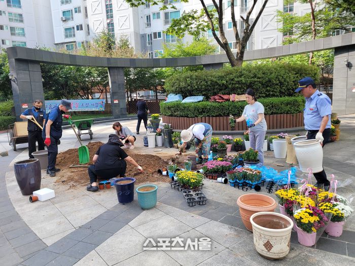 병점역 동문굿모닝힐 입주민들이 폐화분을 활용해 꽃길 만들기 활동을 하고 있다.제공=화성시